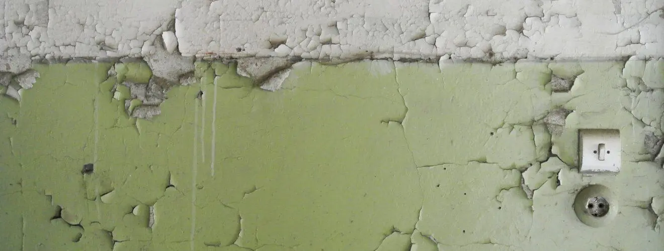 Wand mit abblätternder Farbe nach einem Wasserschaden
